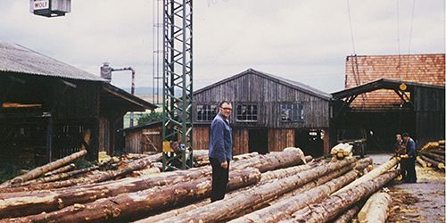 Richard Wissing stehend auf einer Ansammlung liegender Baumstämme