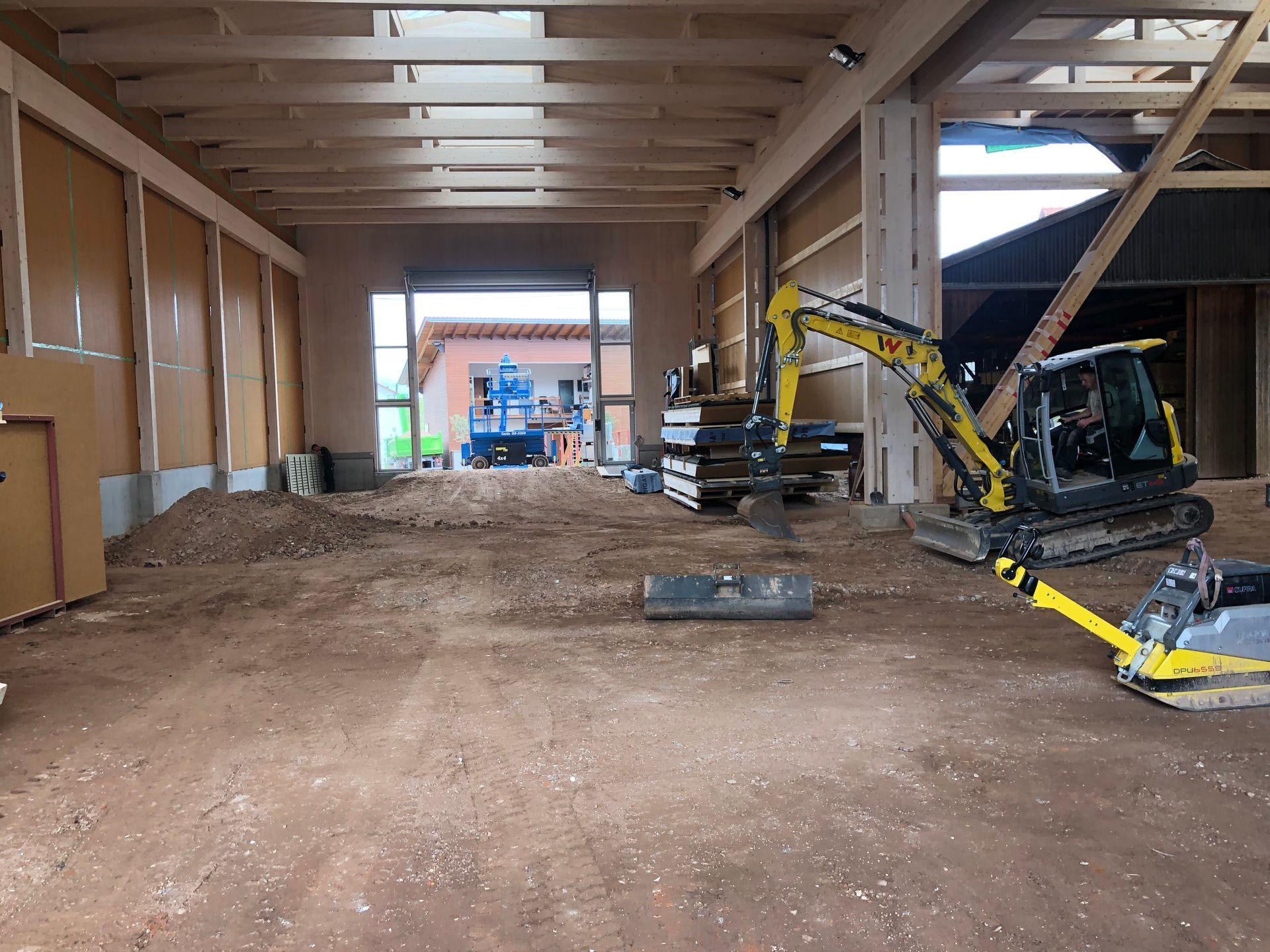 Das Innere der Halle, Ein Bagger ebnet gerade den Boden.