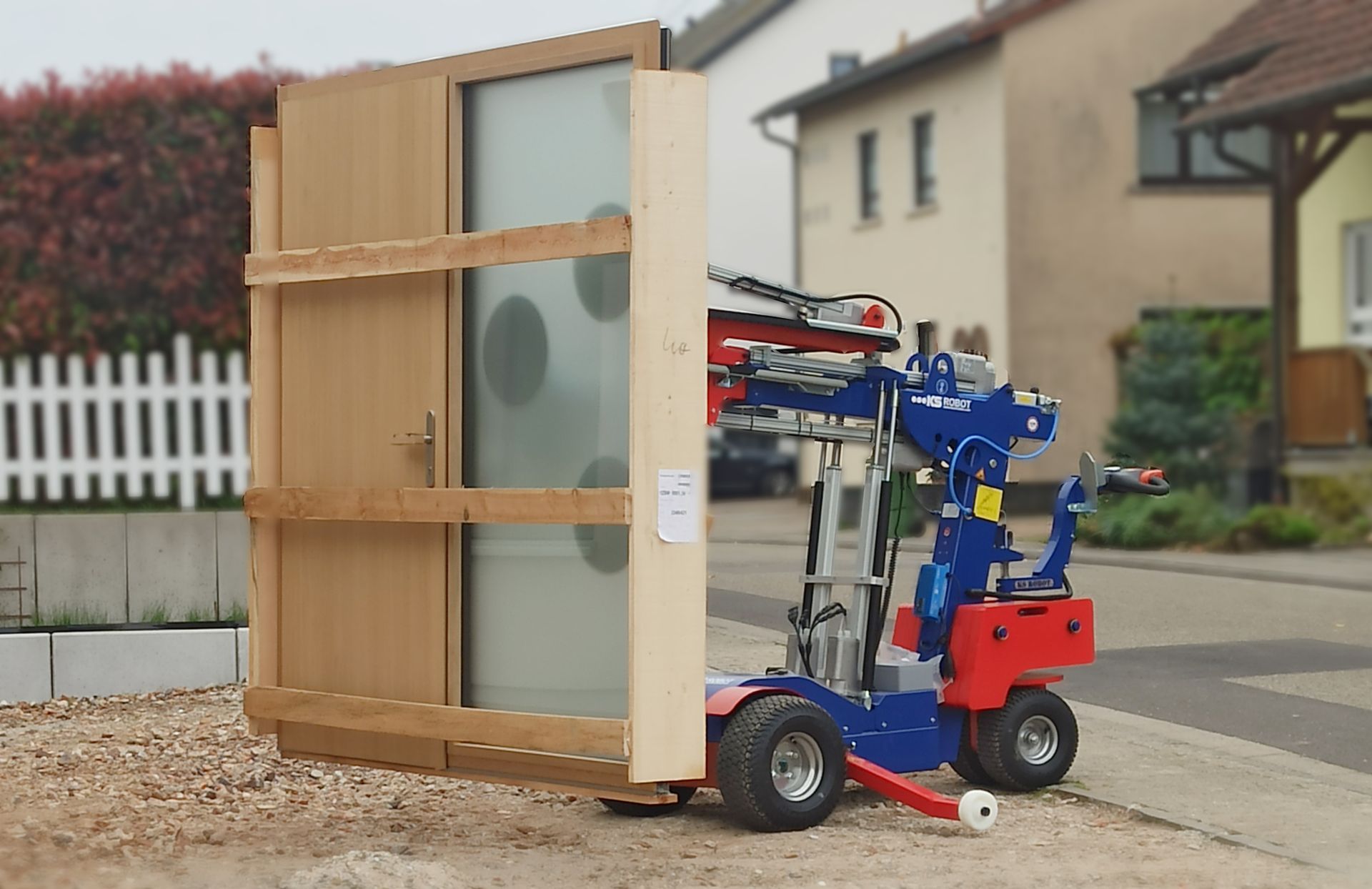 Ein Vakuumsauger der gerade ein Glastürenelement geladen hat und dieses mit Hilfe dreier Saugnäpfe hält