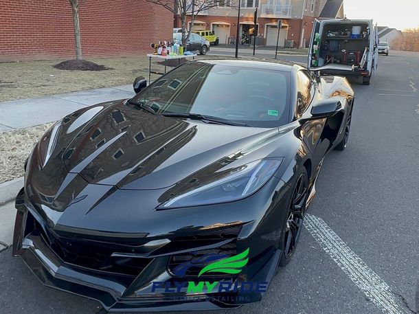 Detailer inspecting polished black paint