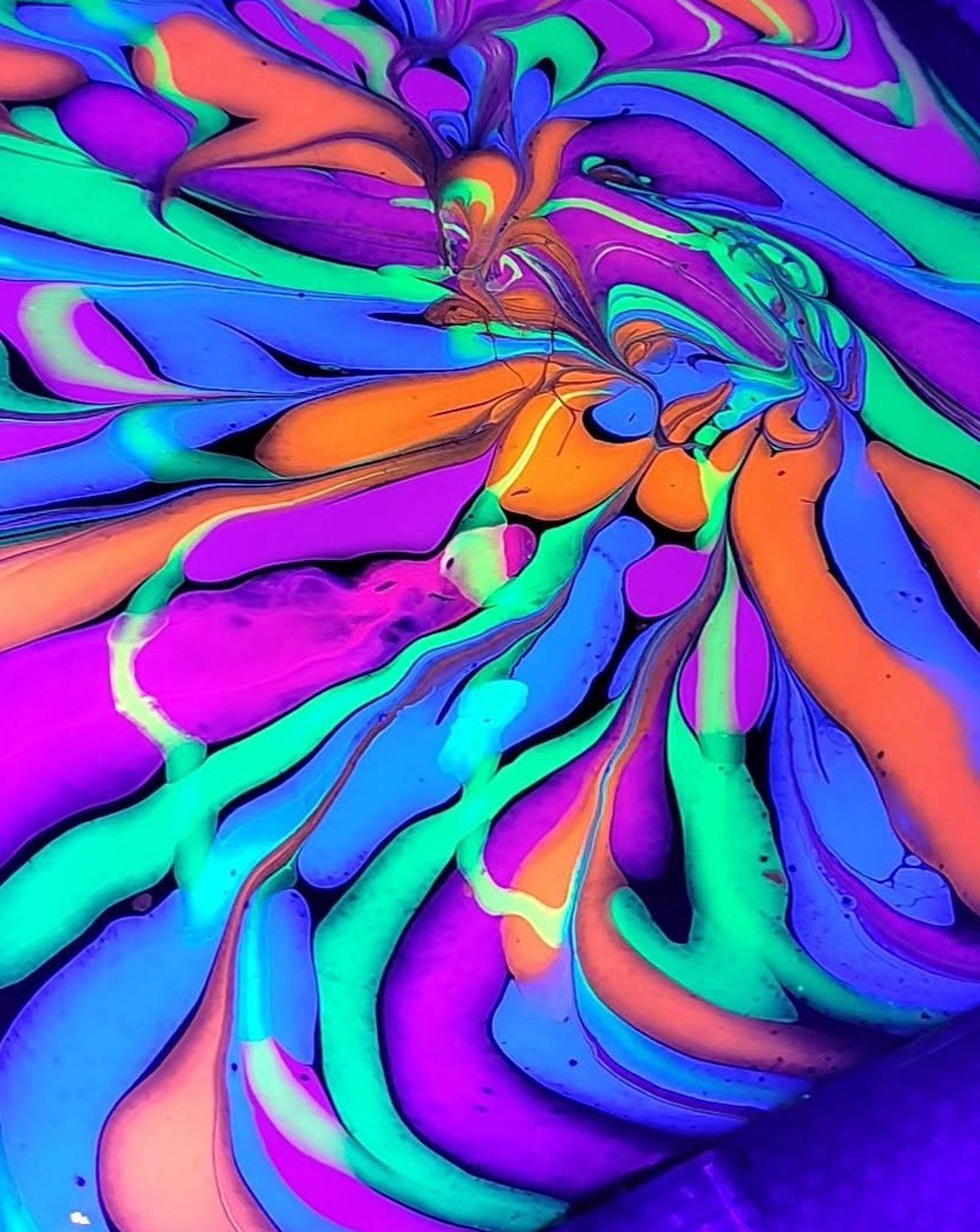 A fluid art canvas by Jessica Marcantel, poured in neon orange, teal and violet and photographed under blacklight
