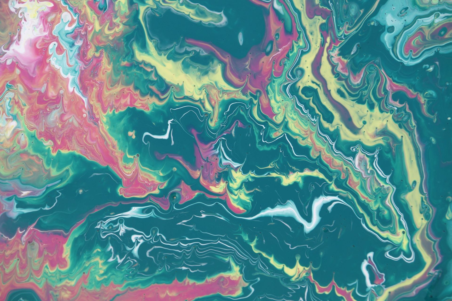 Turquoise, chartreuse and magenta paint pooling into cells on canvas