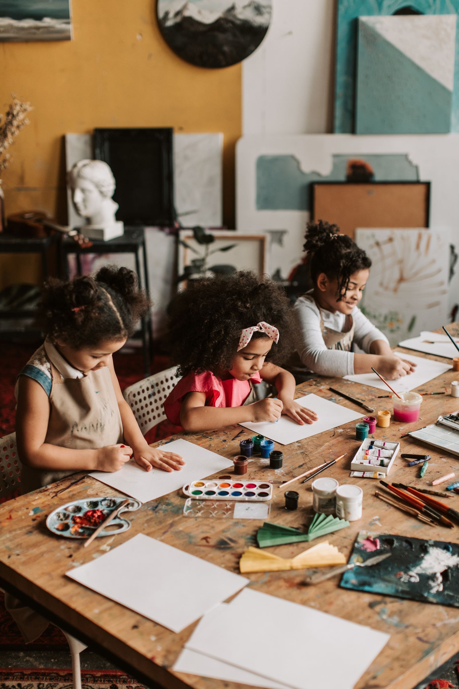 Two young girls drawing side by side at a family friendly art session
