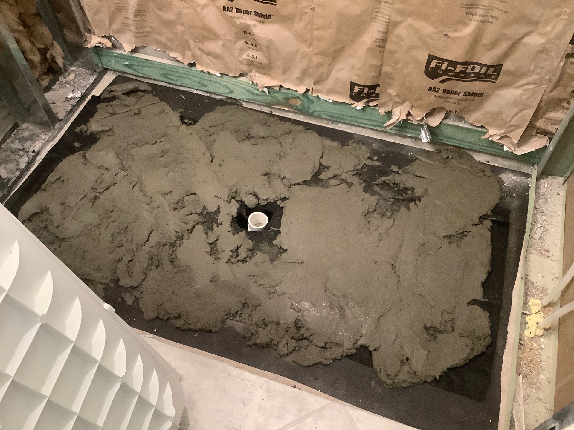 A large pile of concrete is sitting on the floor in a bathroom.