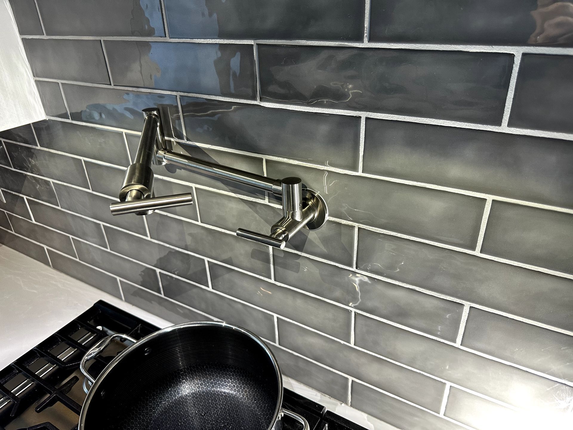 A pot is sitting on top of a stove next to a faucet.