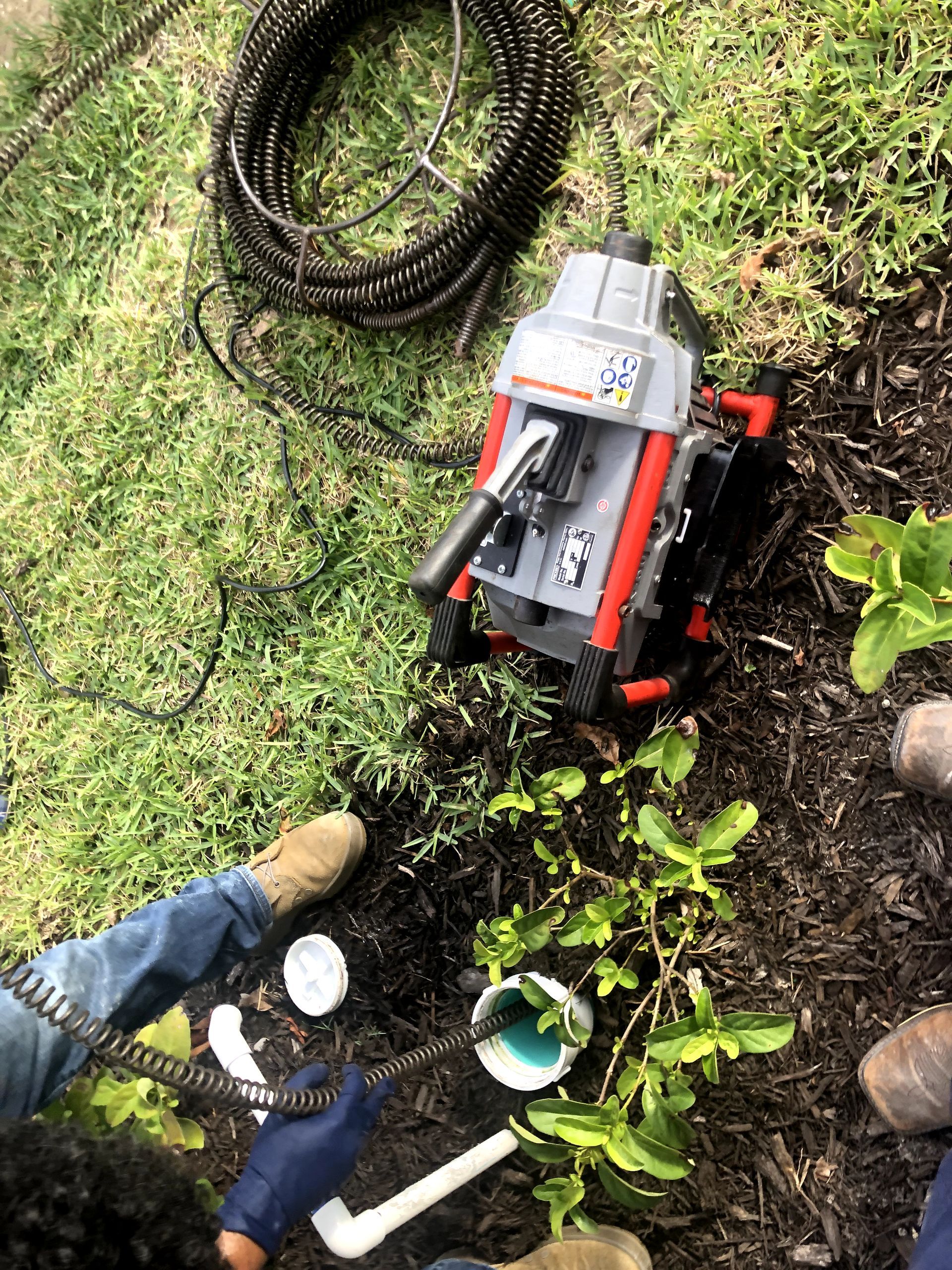 A person is using a machine to clean a drain.