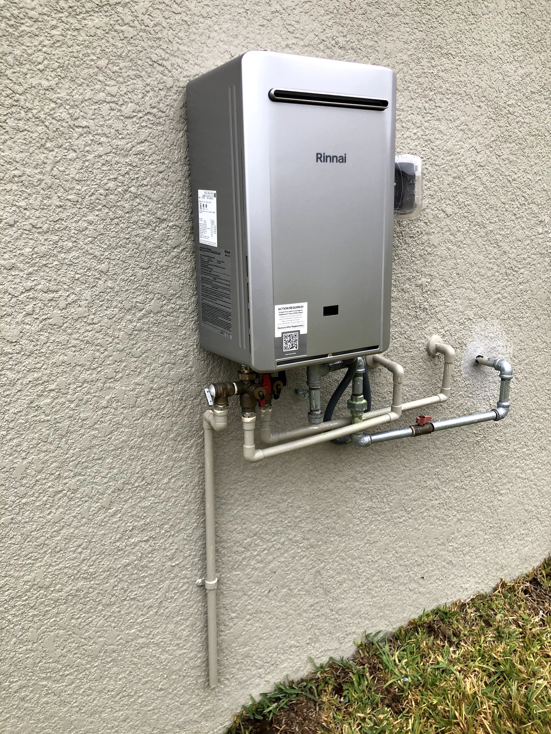 A water heater is attached to the side of a building.