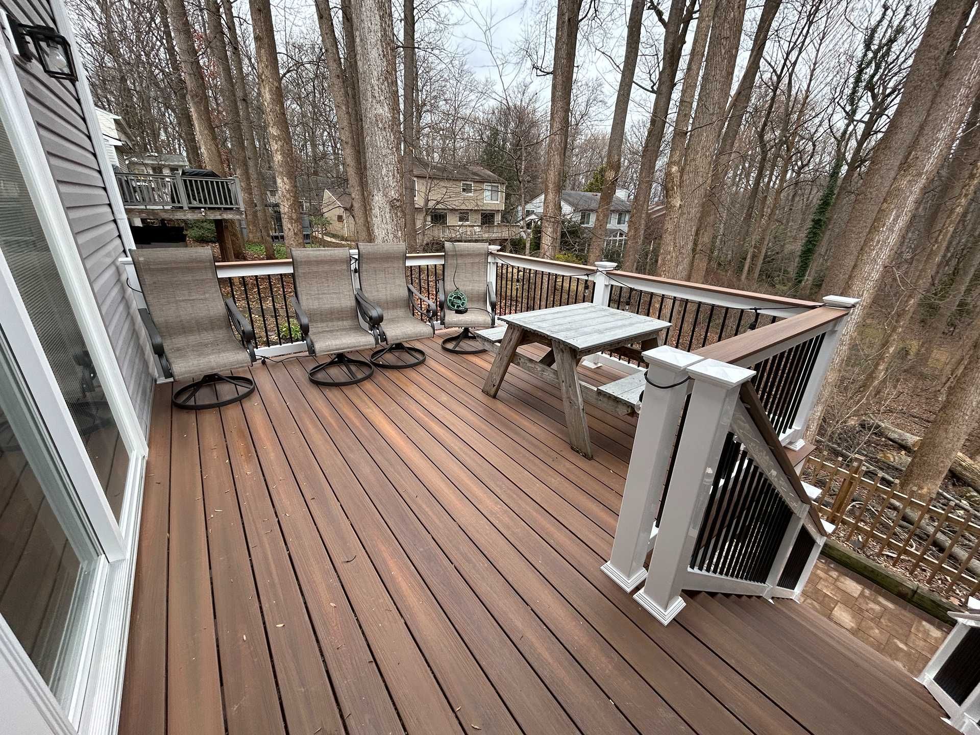 Wooden deck with furniture in a wooded setting.