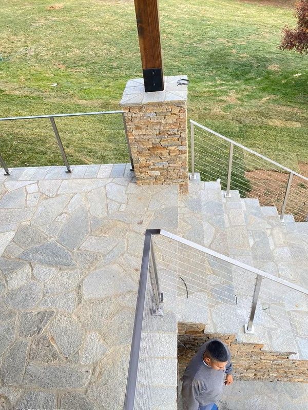 Stone steps leading down with metal railings; a child is walking down the stairs.