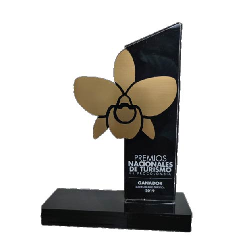 Black glass trophy with gold flower emblem and Spanish text on a base