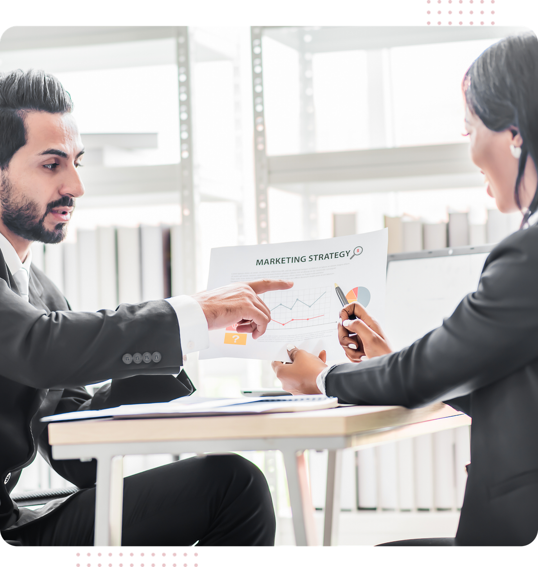 A man and a woman are sitting at a table looking at a piece of paper.