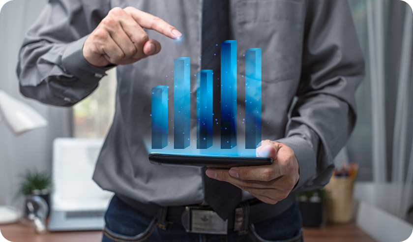 A man is holding a tablet with a graph on it.