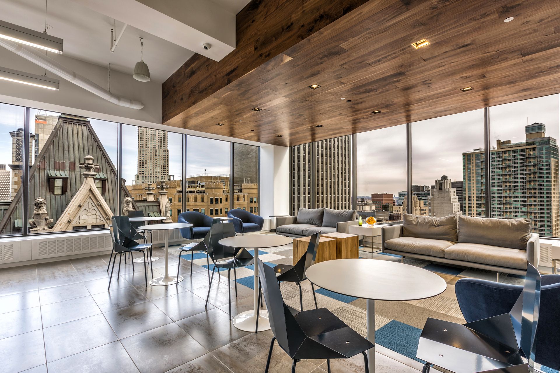 Modern kitchen with wood floors, island with red stools, black cabinets, and open to dining area.