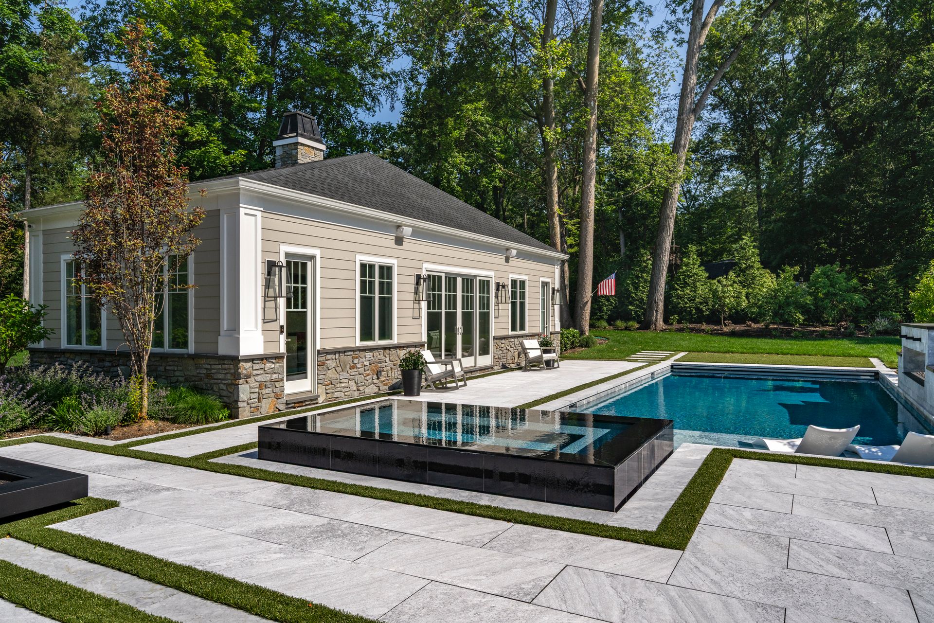 Poolside cabana with pool, patio, and lush landscaping.