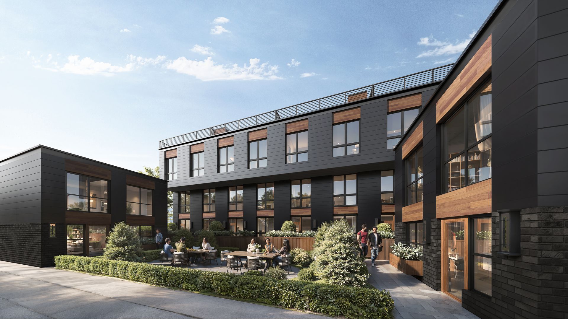 Modern black building with wooden accents, courtyard with people at tables, sunny day.