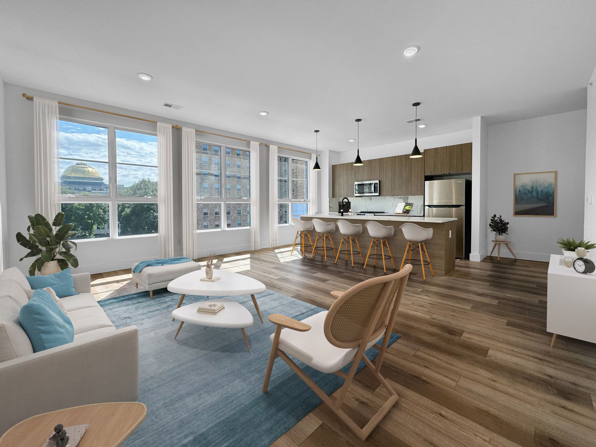 Modern apartment interior with living room, kitchen, and dining area. Large windows, light wood floors, and blue accents.