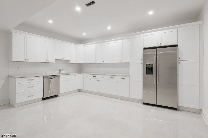 White kitchen with stainless steel appliances and white cabinetry.