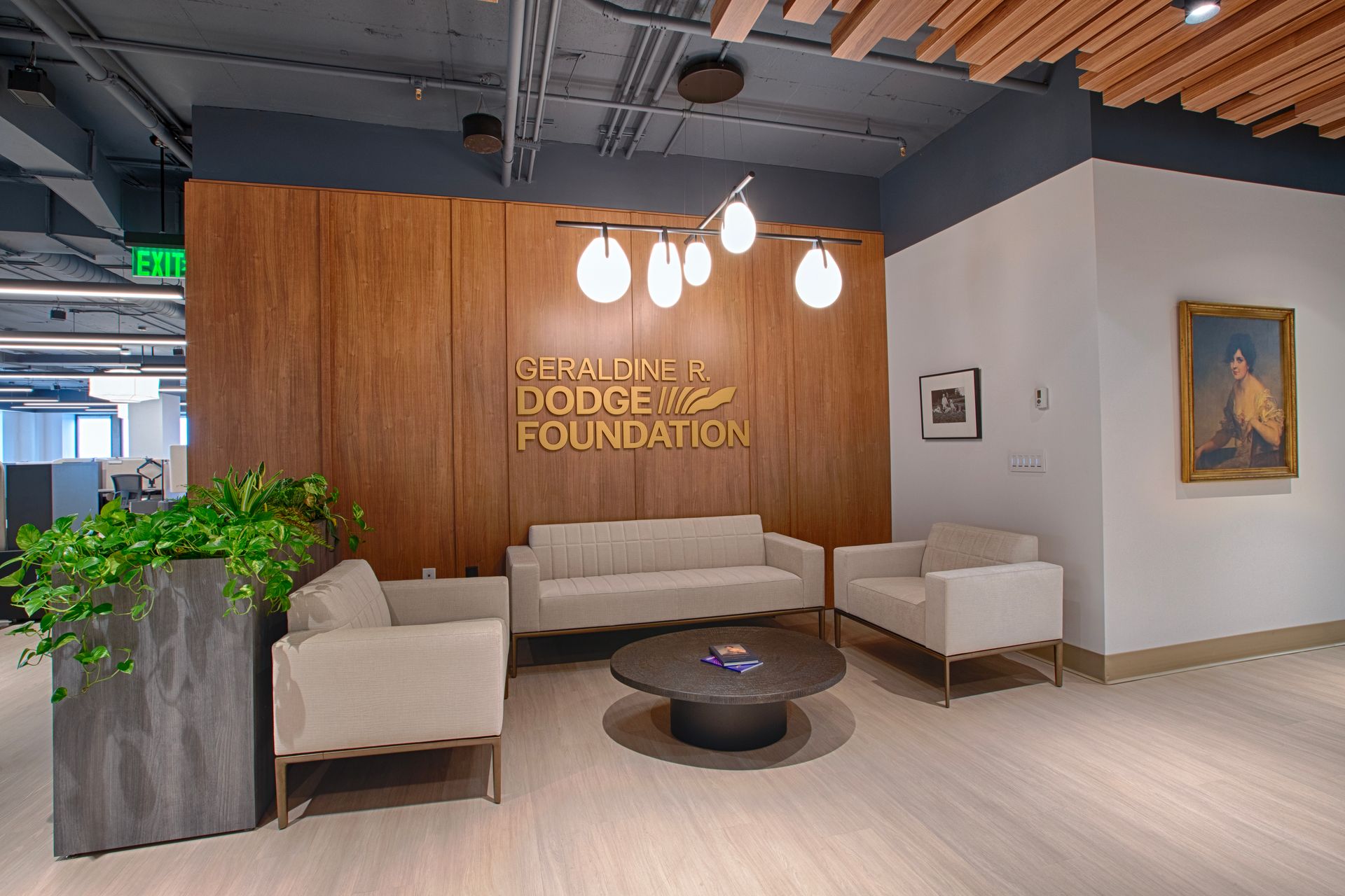 Lounge area with  wood paneling, white seating, and a small round table.