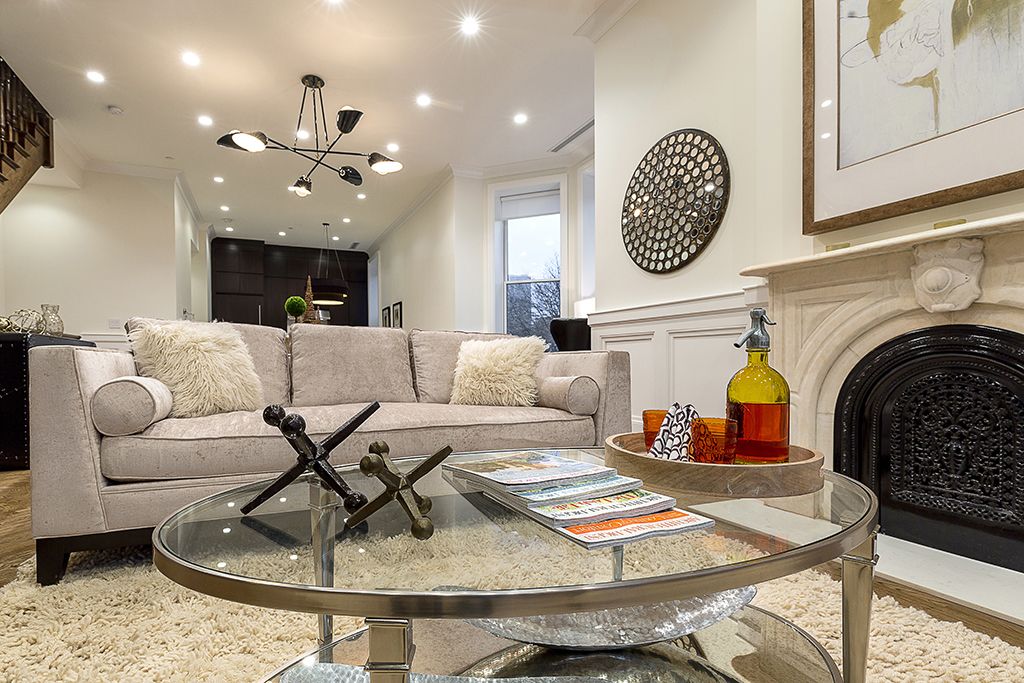 Living room with sofa, coffee table, fireplace, and chandelier.