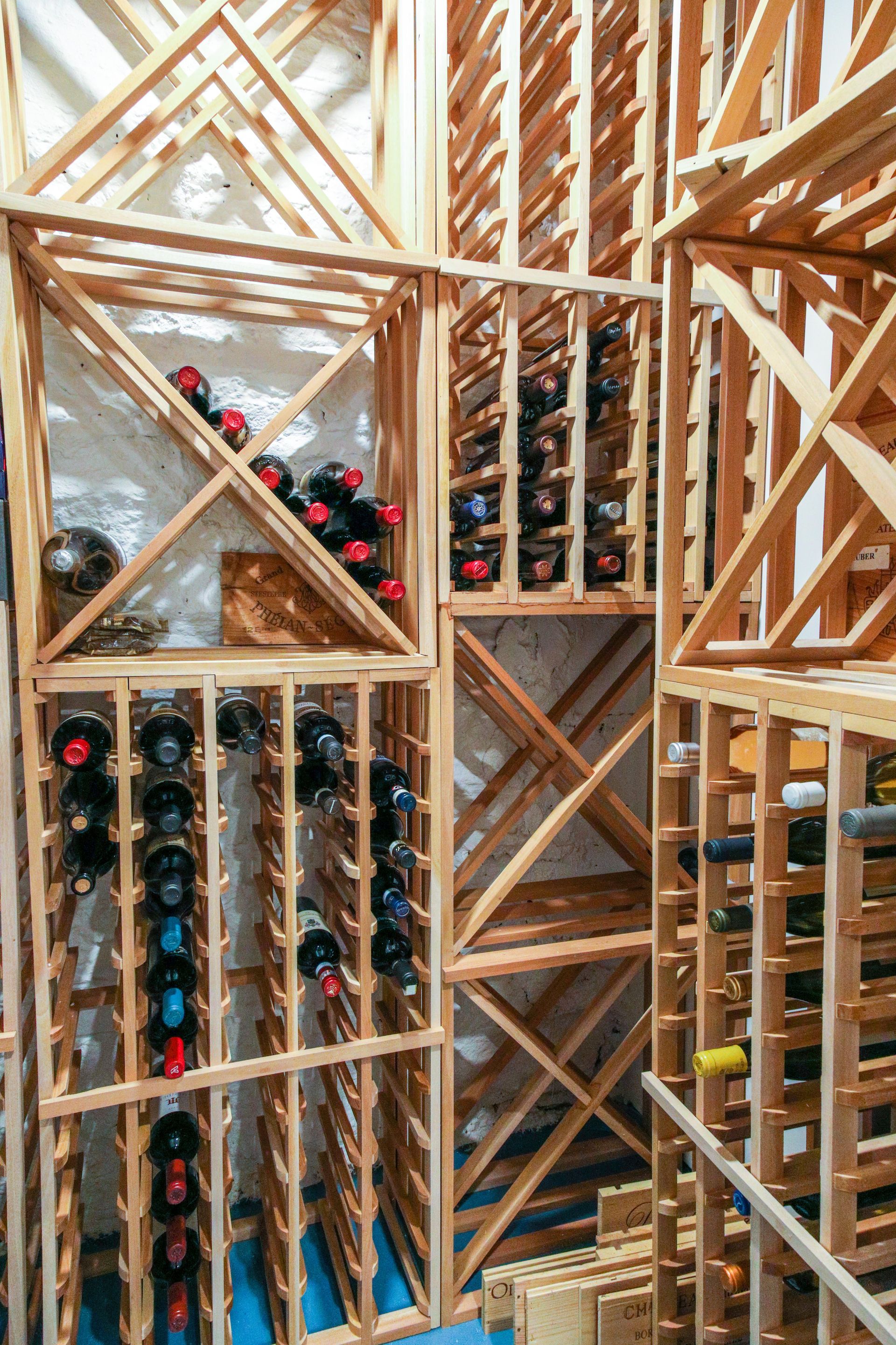 Wooden wine racks filled with various wine bottles.