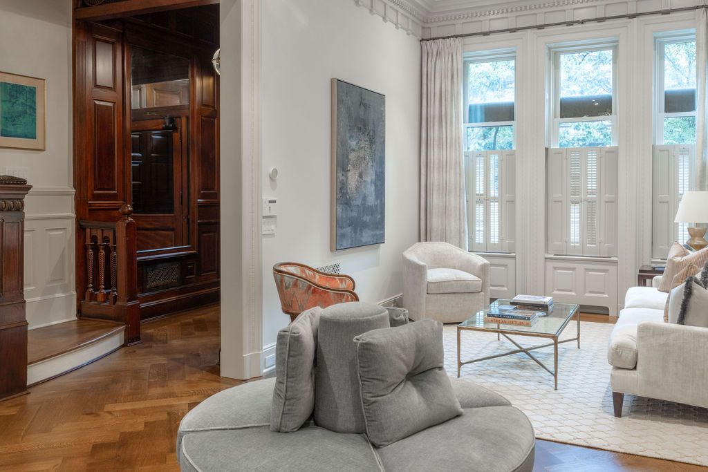 Living room with round sofa, white walls, and ornate wood door.