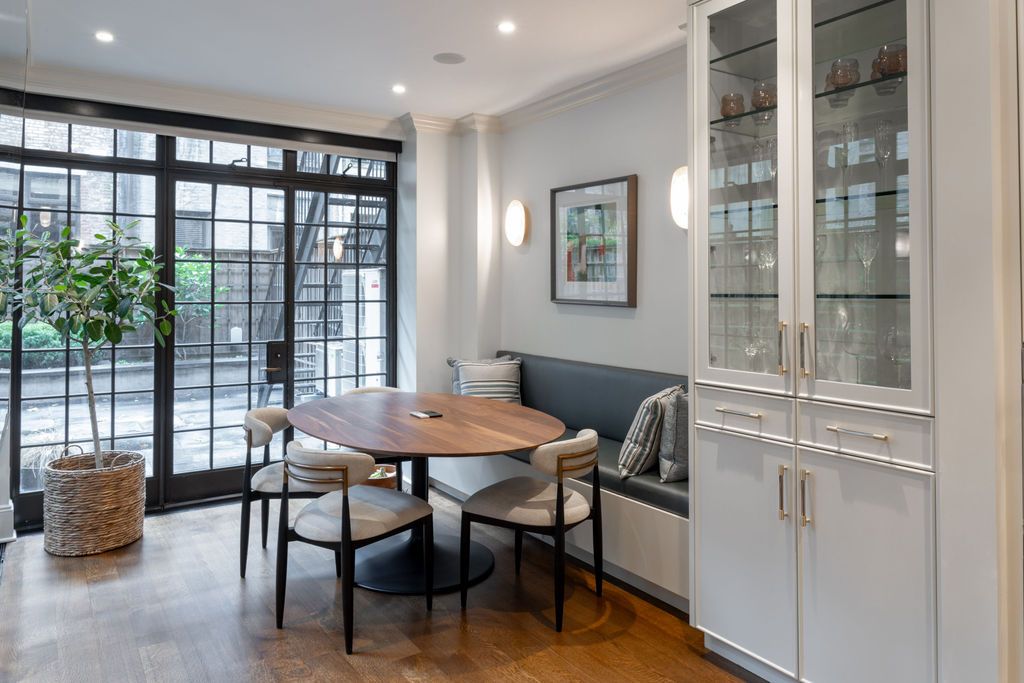 Dining area with table, chairs, built-in bench, glass doors, and a white cabinet.