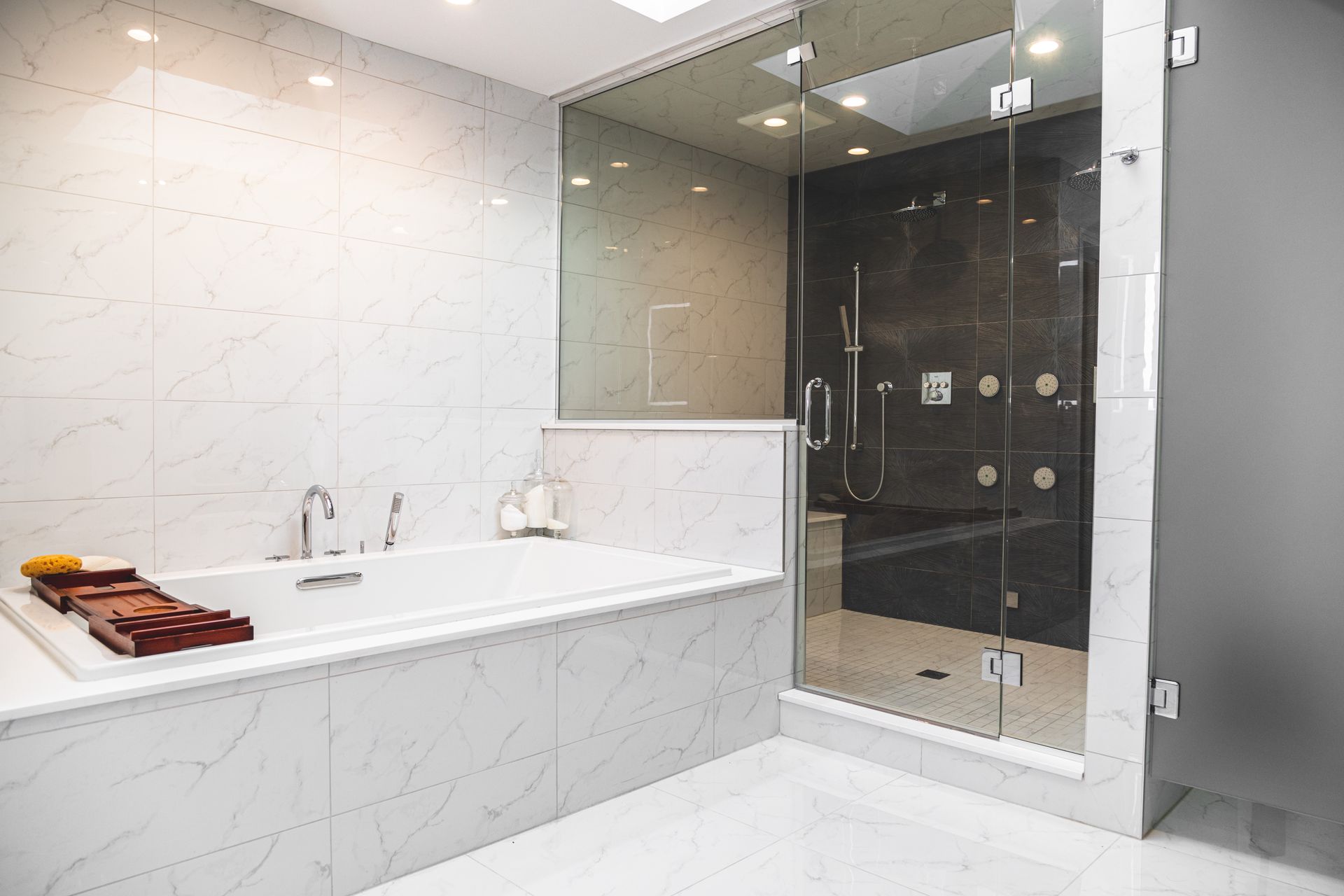 Modern bathroom with a white bathtub and glass shower, white marble walls and floor.