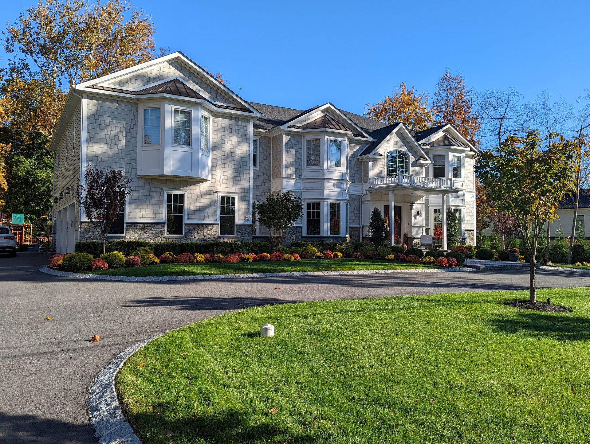 Modern kitchen with wood floors, island with red stools, black cabinets, and open to dining area.
