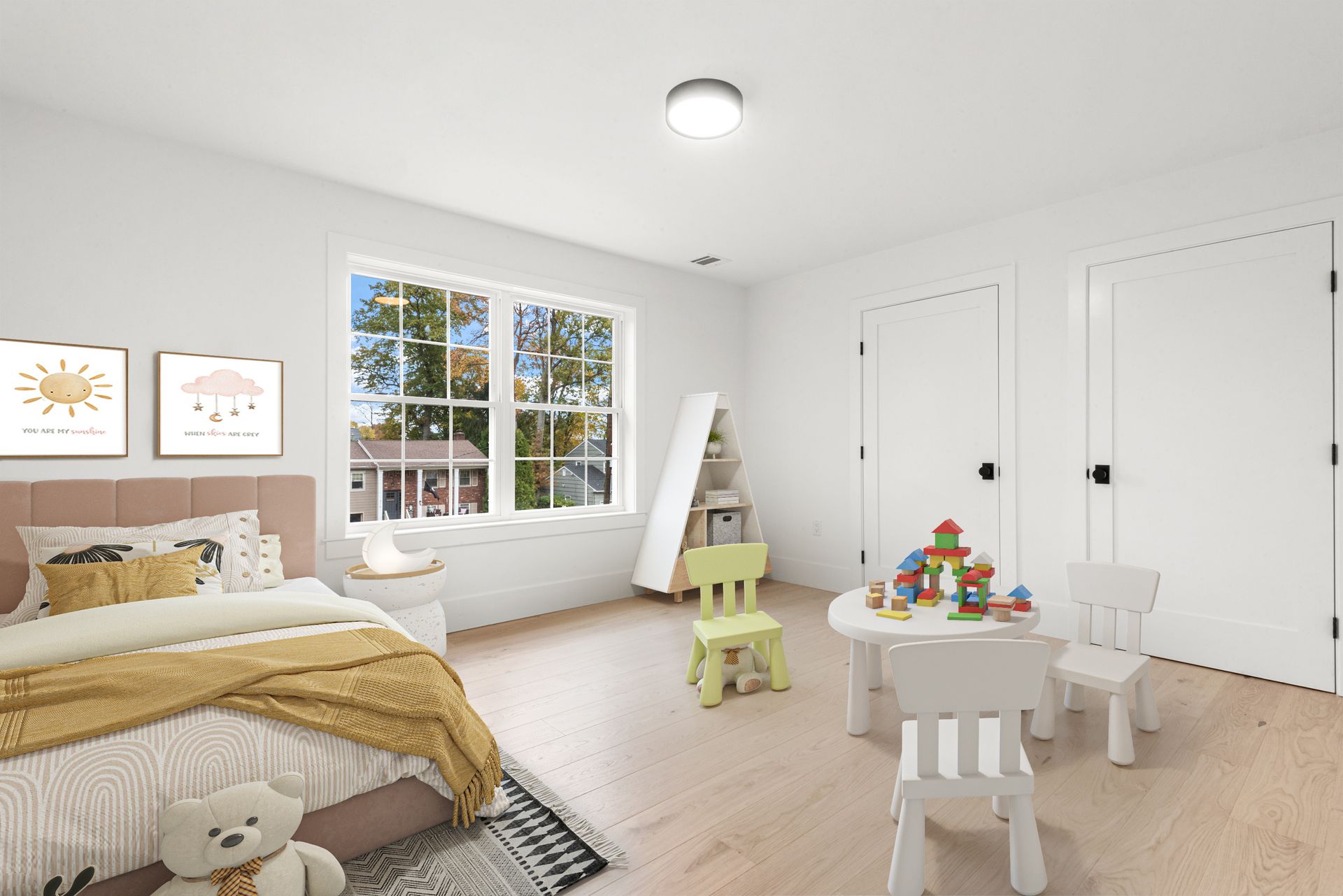 Child's bedroom with bed, play table, two chairs, a bookshelf, and a window.