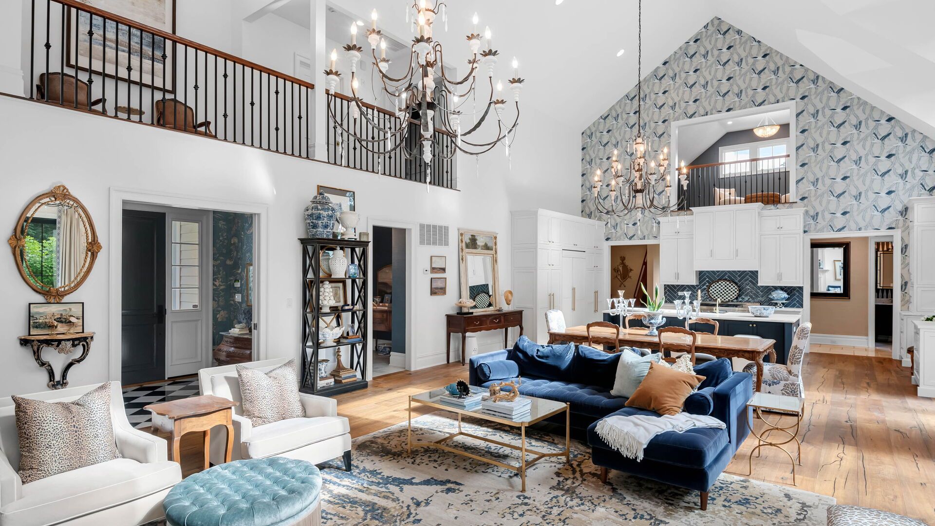 Spacious living room with high ceilings, blue velvet sofa, and a balcony.