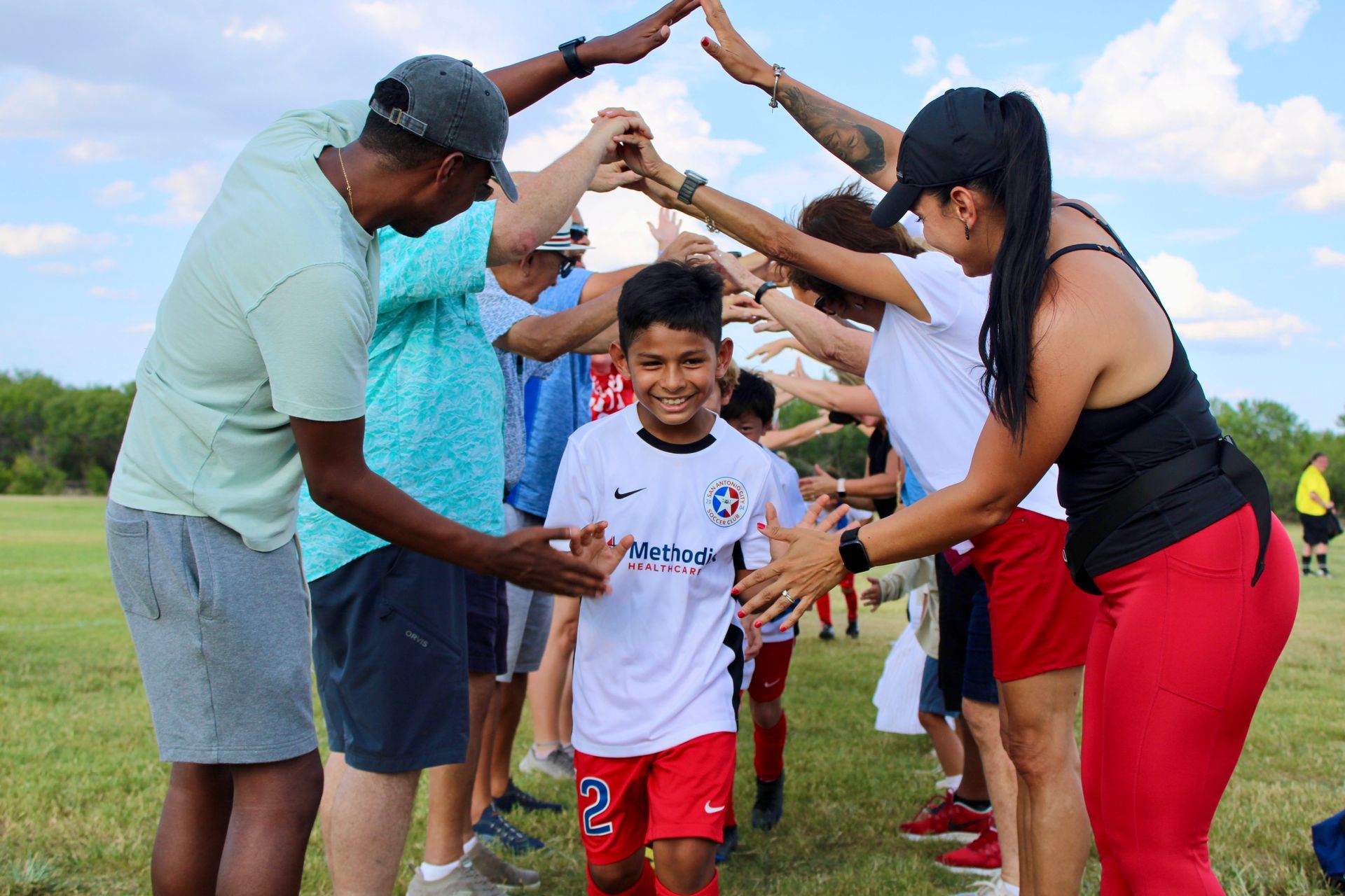 Parents giving high fives to youth players for San Antonio City Soccer Club