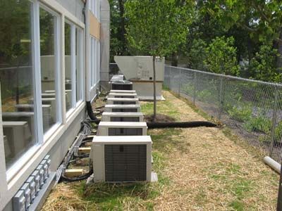 A row of air conditioners are sitting outside of a building