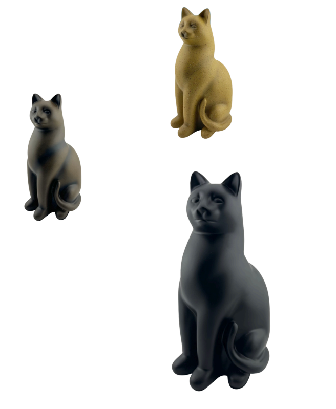 Three cat figurines: black, gold, and black, seated on a white background.