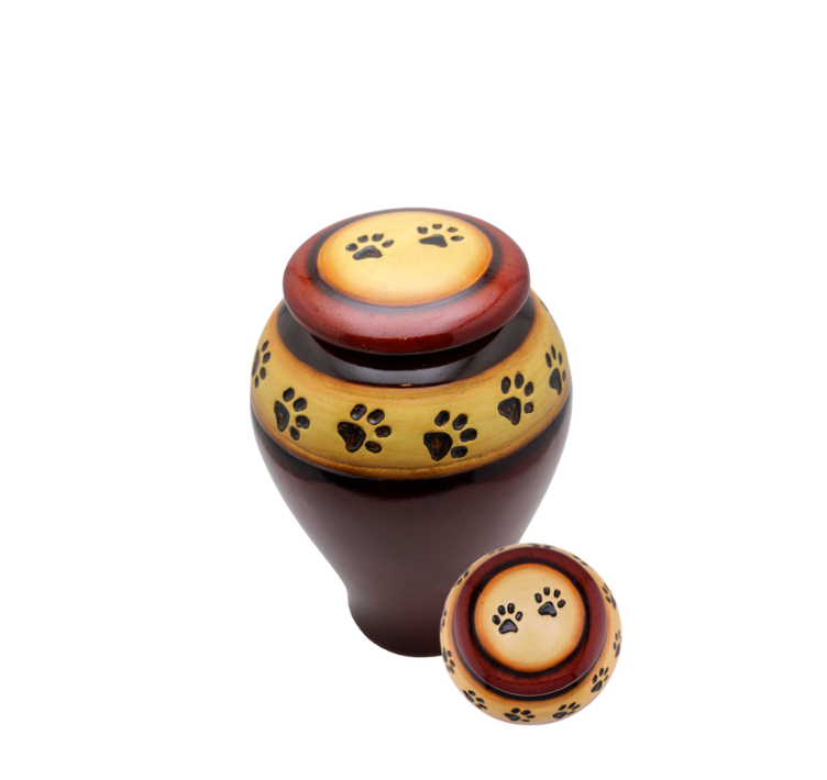 Decorative brown and yellow urn with paw prints and a matching lid beside it