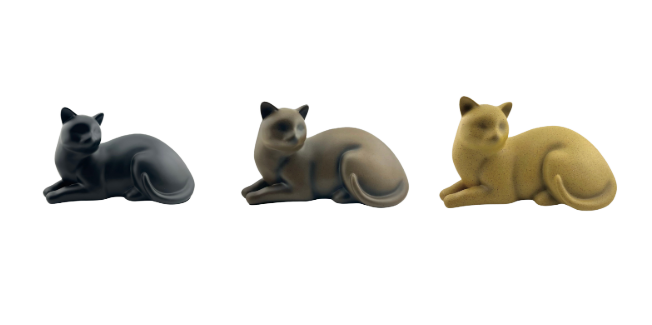 Three curled-up cat figurines in black, gray, and tan on a white background