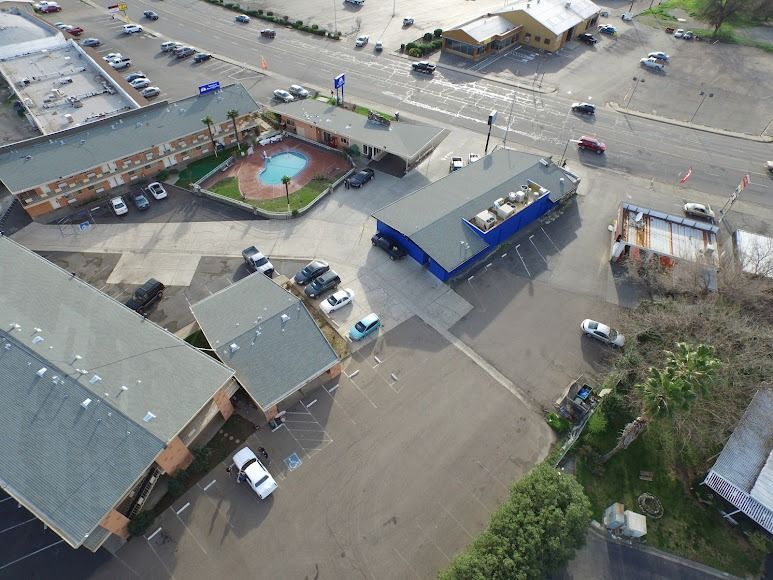 Aerial view of a flooded parking lot with buildings, cars, and a small pool area.