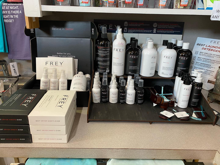 Display of beauty and hair products on a counter, with black and white bottles and boxed items in a salon shop