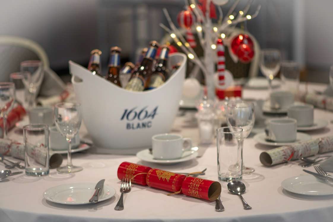 Festive table setting with champagne bottles, glasses, and red holiday decorations