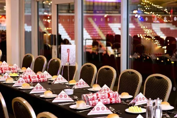 Decorated banquet tables with desserts and wine glasses in a warmly lit event hall