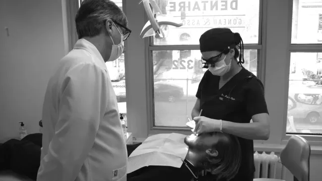Gros plan sur une bouche souriante montrant des dents d'un blanc éclatant et des lèvres brillantes.