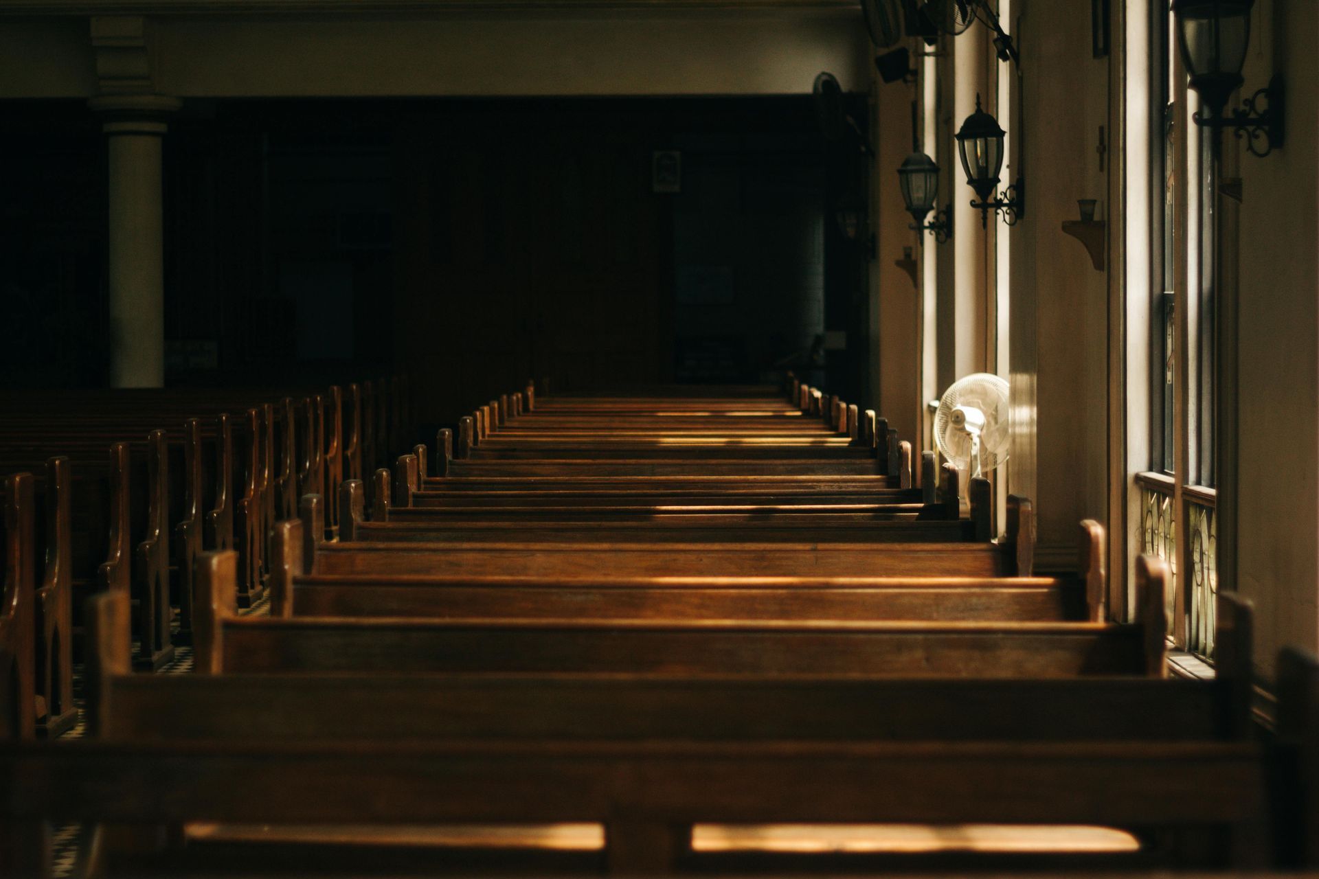 A row of wooden benches in an empty church.