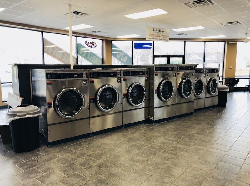 A laundromat filled with lots of washing machines and dryers.