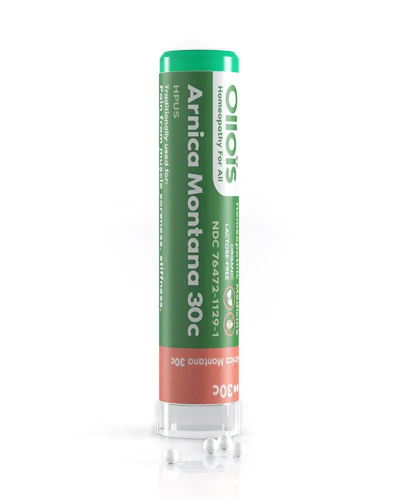 A tube of Boiron Arnica Montana 30c homeopathic medicine, white with a green and red label, resting on a white surface.