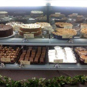 Display case with various cakes and pastries, including layered cakes and brownies.