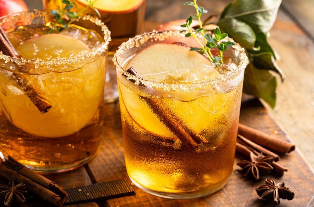 Cocktails with apple slices, cinnamon sticks, and sugared rims.