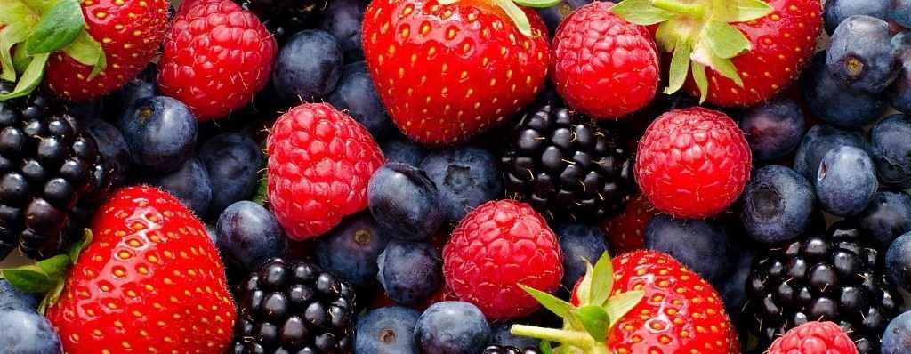 Close-up of various fresh berries including strawberries, raspberries, blackberries, and blueberries.