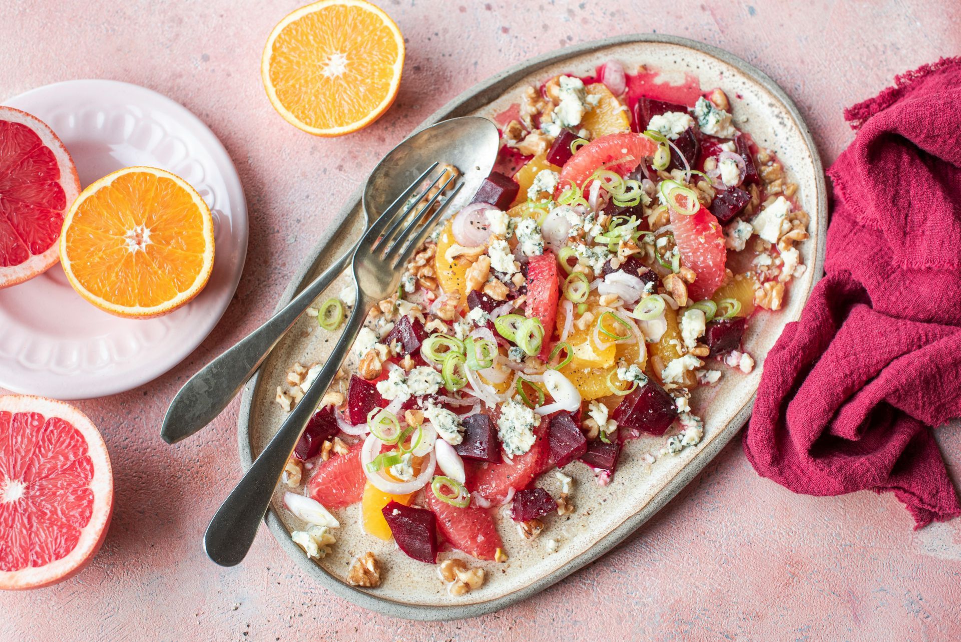 Citrus salad with oranges, grapefruit, beets, walnuts, and goat cheese on a plate.