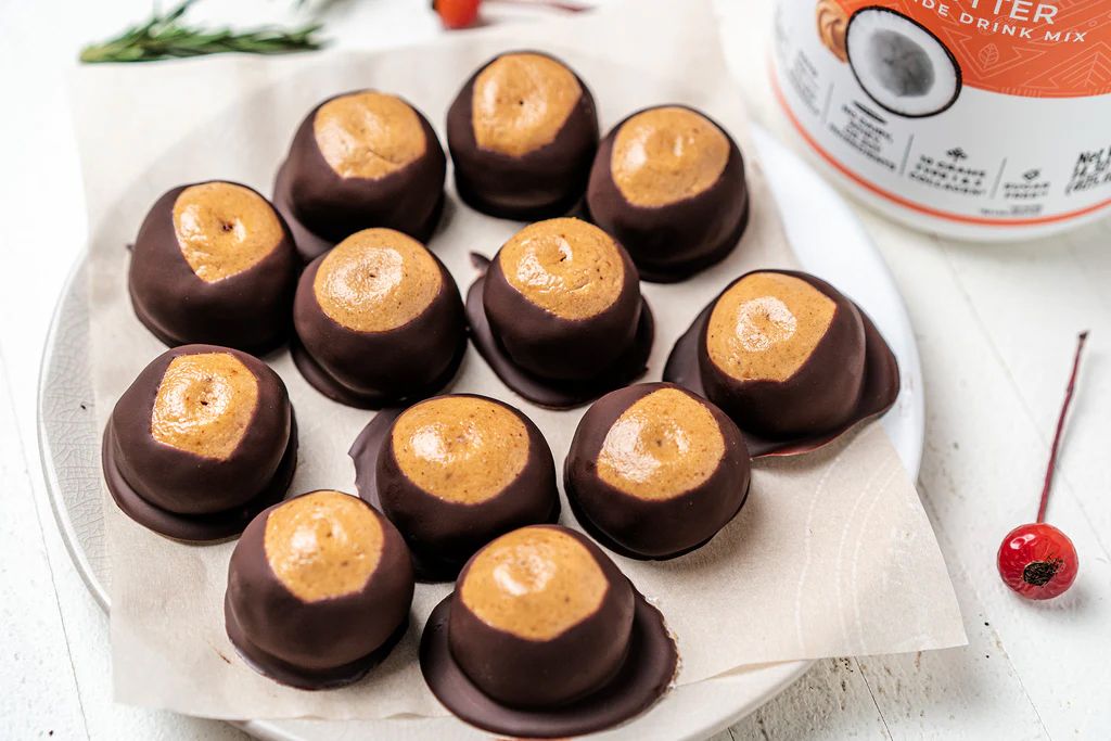 Ohio Buckeye candies, peanut butter centers dipped in dark chocolate, arranged on a plate.