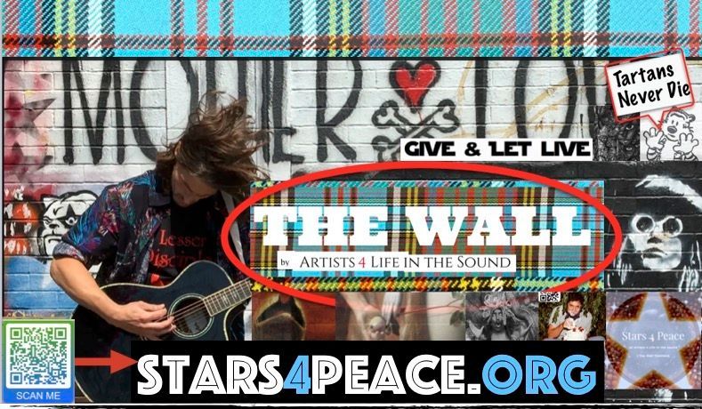 A musician with long hair plays guitar in front of a graffiti wall with the words