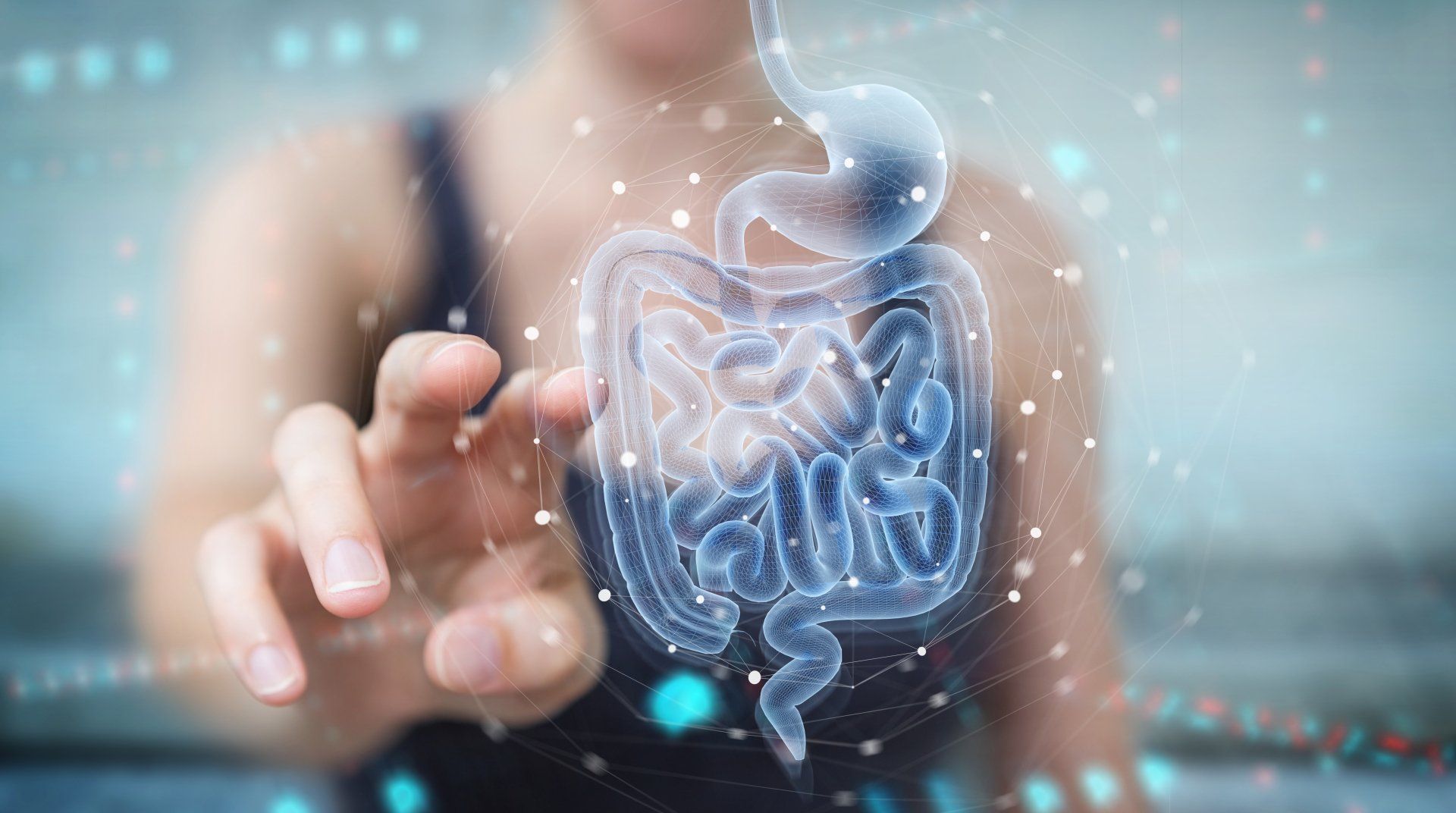 A woman reaching towards a glowing digital model of the human digestive system.